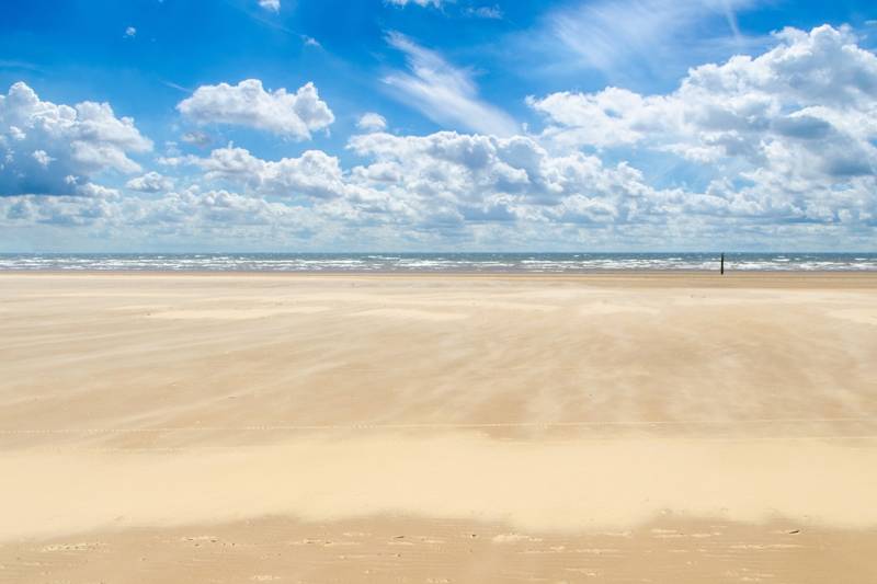 Wolken strand met wind